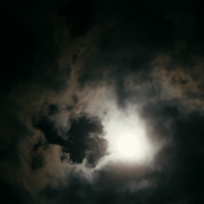 Night Waves by Jason Sudak. Screen grab from the film, of the night sky with moon and backlit clouds. 